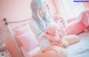 A woman sitting on a bed holding a pink stuffed animal.