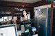 A woman standing behind a counter in a coffee shop.