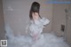 A woman is taking a bath in a bathtub filled with foam.