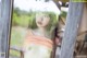 A woman in a straw hat is looking out of a window.