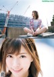 A young woman sitting on a ledge in front of a construction site.